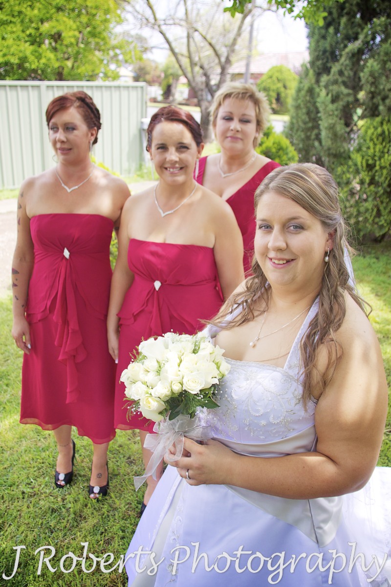 Bride smiling with bridesmaids in red - wedding photography sydney